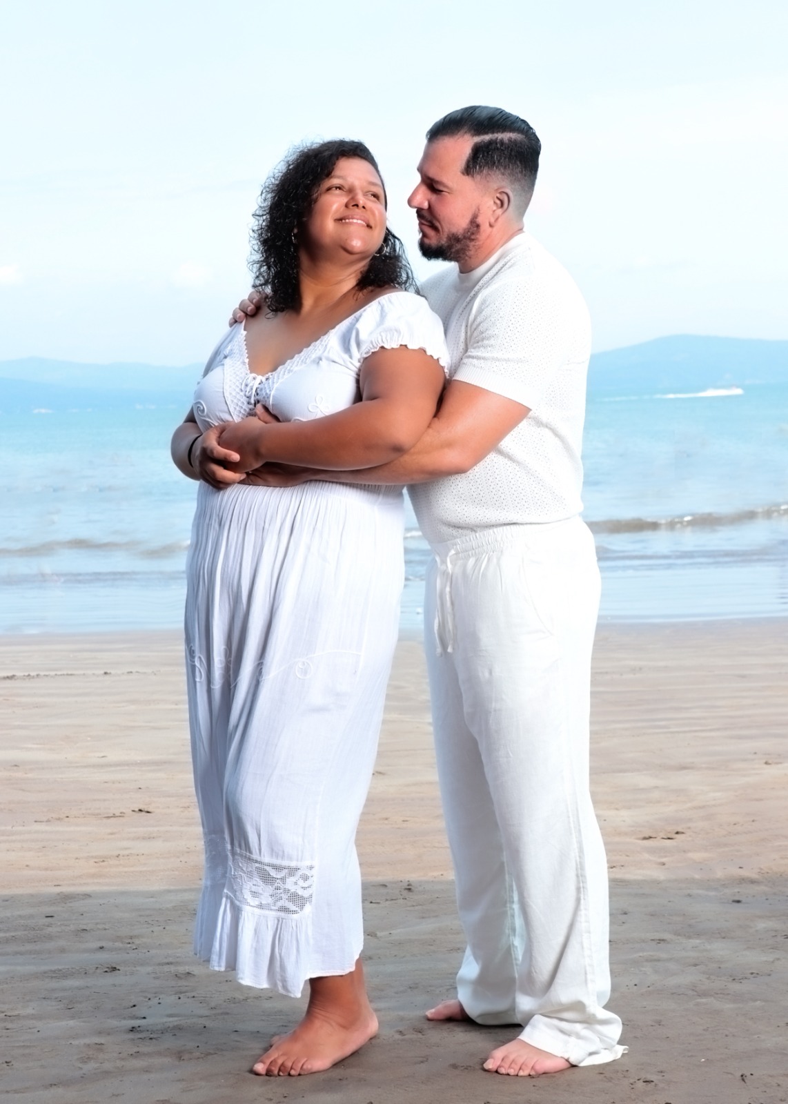Adriel abrazando a Cinthya frente al mar